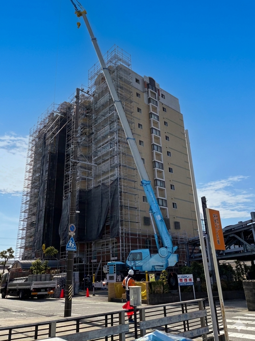 クレーンで進む足場組立の様子｜大規模修繕工事（岡崎市）